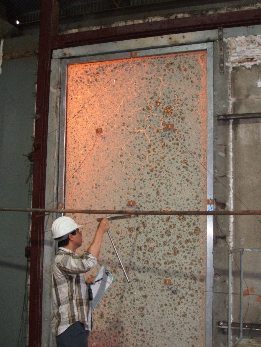 EI fire resistant glass panel during a fire test, with the intumescent gel reacting to the heat